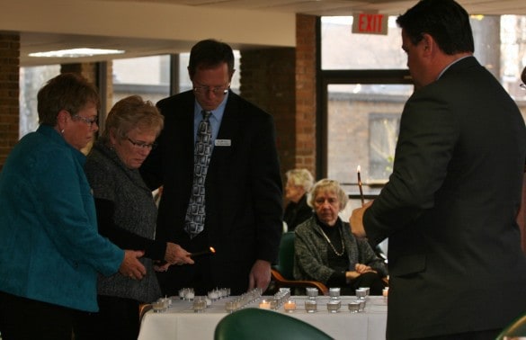 File photo of family members lighting a candle during the Service of Remembrance last year. 