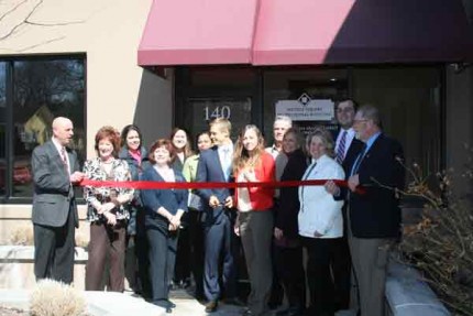 Dr. Nate Keiser (center) gets ready to cut the ribbon for his new practice. He's flanked by staff and Chelsea Area Chamber of Commerce members.