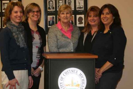 File photo of Mary Picklesimer (center) with Laura Kaier on her right surrounded by the ladies of the Chelsea City Office staff.  