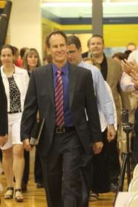 Honored educator Dave Pollay enters the gym.