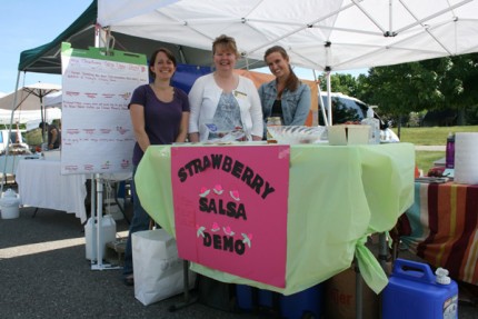 Ashley Miller-Helmholdt, market manager, xx and xx pose for a photo at the strawberry salsa demonstration booth at the Bushel Basket Farmers' Market Wednesday.