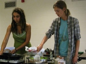 Erin sautés Garlic Stir-Fried Snow Peas while Beth prepares toasted sesame seeds.