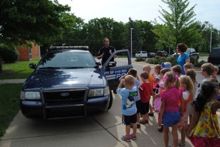 Courtesy photo. Chelsea Police Officer Shane Sumner shows the Safety Town participants his police car.