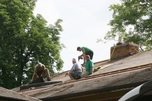 Tom Girard's friends work on his roof. 