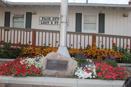 Fair flowers in front with memorial rock.