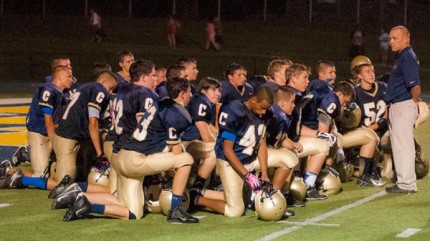 Photo by Bob Garypie. Team kneels at the end of the game. 
