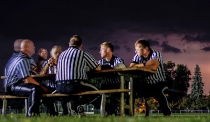 Game officials look to the sky during a lightning delay during Friday night's football game. 