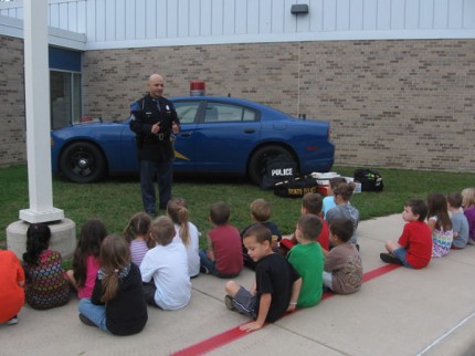 Michigan State Police Sgt. xx talk to children at North Creek about safety.