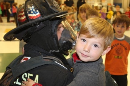 Firefighter Rob Stelzer III hugs a child.