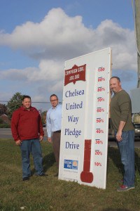 Honorary Chairman of the Chelsea United Way Campaign Ed Greenleaf, Mike Kapolka and Eric Keaton pose for a photo with the fundraising thermometer outside Chelsea Lanes Tuesday.