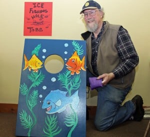 Tim Eiseman with one of the acrylic fish he painted for the kids' games.