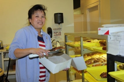 Owner Kim Yam begins to fill a pastry box inside her new business Chelsea Bakery.