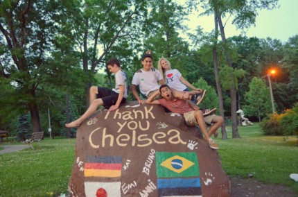 Courtesy photo. The Chelsea High School exchange students sit on the rock they painted before they left for their home countries earlier this month. 