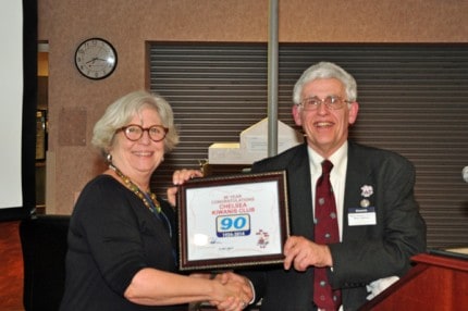 Courtesy photo by John Knox. Club President Mary Schroer receives a certificate honoring the club's 90th anniversary from Michigan District Governor Stan Nelson.