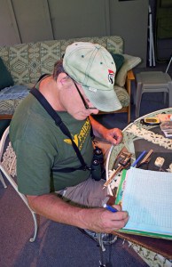 Photo by Tom Hodgson. Allen Chartier records data before releasing a banded bird. 