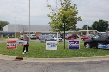 Probate judge candidate places a sign at the Chelsea poling place Tuesday morning.