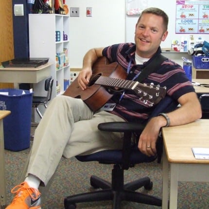 Photo by Megan Hayduk. Eric Robinson and his guitar wearing his signature orange shoes. 