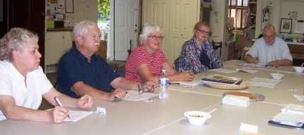 Photo by Lisa Carolin. Members of the Dexter Area Historical Society meet to hear the amazing news that the Gordon Hall mortgage has been paid in full. 