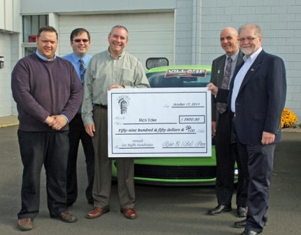 From left, Eddie Greenleaf, Ian Boone, Rick Eder, Bruce Szcodronski and Bob Pierece pose with the check in front of a car at Village Motor Sales, which was one of the prizes of the Chelsea Chamber of Commerce fundraising car raffle.  