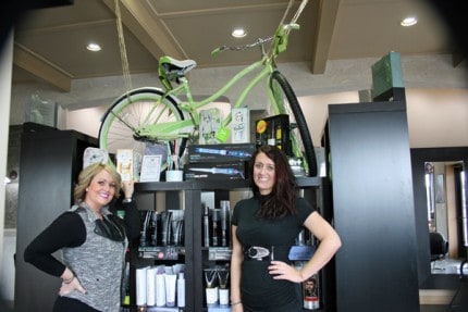 Susan Frederick and Rushelle Spaulding pose in front of the Huffy bike that will be given away on Dec. 15 at Salon Rushelle.