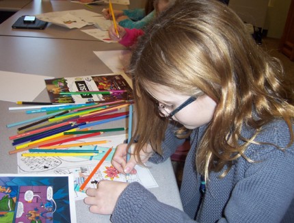 A student hard at work on her comic book design during a series of workshops.