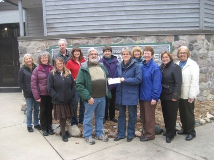 Back row: Waterloo Natural History Association Board Members John Lixey, Leanne Zatkovich, Kathy Claflin and Jennifer Puntenney. Front row: Wendy Broshar, Carol Strahler, Meg Gower, Chairperson Gregg Burg being handed check by Homemakers Club President Janis Horning, event Co-chair Patty McCarthy, Secretary Kay Heller and Treasurer Diane Horning.
