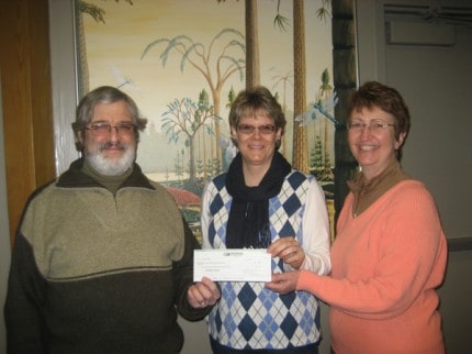 WNHA Board Chairperson Gregg Burg being handed check by Homemakers Club President Janis Horning and Event Co-chair Patty McCarthy.