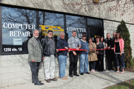 Members of the Chelsea Area Chamber of Commerce come together for a group photo outside The Computer Source Monday morning.