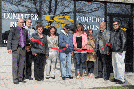 xxx  cuts the ribbon outside the new location of The Computer Source.