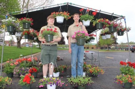 Scouts from Boy Scout Troop 425 with hanging baskets they sold Saturday during a plant sale .