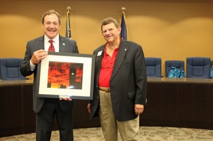 Mayor Jason Lindauer presents a framed photo of the clocktower to Frankenmuth Mayor Gary Rupprecht.