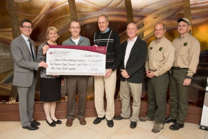 Courtesy photo. Michael Miller, chief mission officer of Saint Joseph Mercy Health System and Nancy Graebner, president and CEO of St. Joseph Mercy Chelsea, present a check for $250,000 to Jeff Hardcastle, HWPI board chair; Ron Olson, section chief of the Dept. of Natural Resources (DNR) Parks and Recreation Division; Coy Vaughn, assistant director, Washtenaw County Parks and Recreation Commission; Chuck Dennison, manager, DNR Pinckney Recreation Area and Gary Jones, manager, DNR Waterloo Recreation Area.