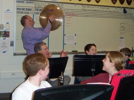 Beach Middle School Principal Nick Angel attempts to play the cymbols during 6th grade band practice.