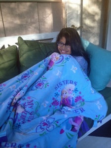 Photo provided by Lisa Hinz-Johnson. Ava Hinz-Johnson cuddles with her friendship blanket at home.