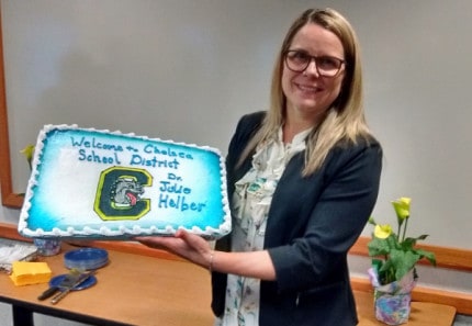Photo by Crystal Hayduk. Julie Helber shows off the decorated cake welcoming her to the district as new superintendent of schools. 