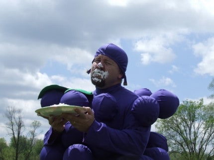 Photo by Crystal Hayduk. North Creek Elementary School Principal Marcus Kaemming eats whipped creme covered grapes (while dressed as a grape) at the recent Wacky Olympics. 