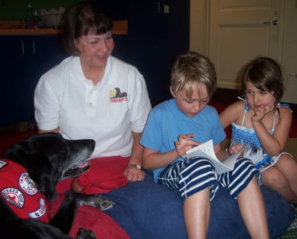 Kids like to read to Sable, the black Labrador retriever.