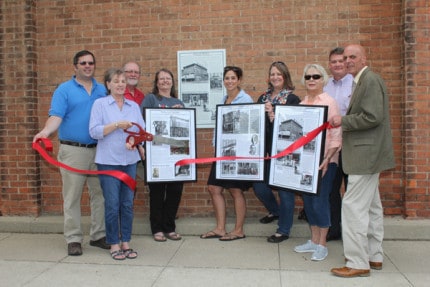 The seventh historic plaque was unveiled this week in downtown Chelsea with a ribbon-cutting ceremony. Pictured from left to right are Ian Boone, Cathy Carter, Bob Pierce, Kathy Beane, Emily Penix, Leslie Surel, Joyce Johnson, John Hannifan and Bruce Sczdronski. 