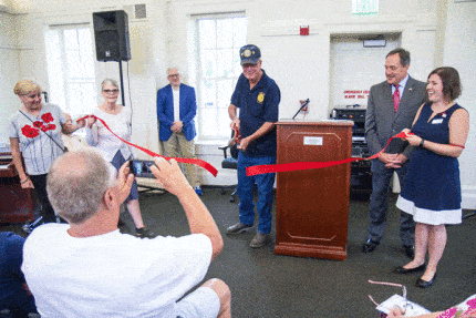 Photo by Burrill Strong. Craig Maier cuts the ribbon at the WWI centennial celebration inside the Chelsea District Library.