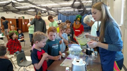 Lindsay Smith helps with summer cooking classes at Camp Gabika. Here, children make different kinds of smoothies from kale, beets and carrots. (Photo from the Chelsea Senior Center.